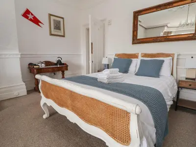 a bedroom with a large bed with a mirror on the wall at Ismay Dining Room Suite - Titanic Interest in Crosby