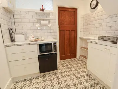 a kitchen with white cabinets and a black dishwasher at Ismay Dining Room Suite - Titanic Interest in Crosby