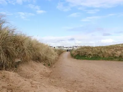 a dirt road with tall grass on the side at Ismay Dining Room Suite - Titanic Interest in Crosby