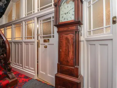 a large grandfather clock sitting in a room at Ismay Dining Room Suite - Titanic Interest in Crosby