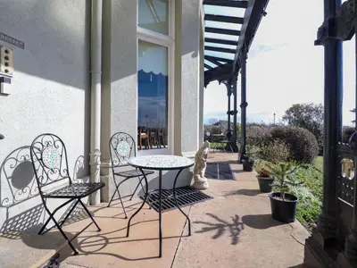 a patio with a table and chairs on a building at Ismay Dining Room Suite - Titanic Interest in Crosby