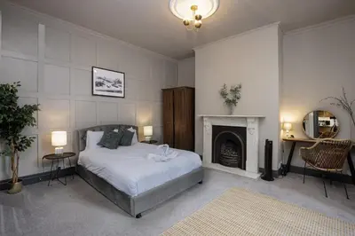 a bedroom with a bed and a fireplace at Bentinck Residence by Sasco Apartments, Lytham St Annes in Lytham St Annes