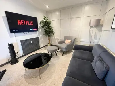 a living room with a couch and a tv at Bentinck Residence by Sasco Apartments, Lytham St Annes in Lytham St Annes