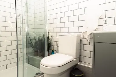 a white bathroom with a toilet and a shower at Elegant 2 bed with hot tub and a host of amenities in Liverpool