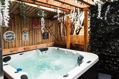a jacuzzi tub in a wooden building at Elegant 2 bed with hot tub and a host of amenities in Liverpool