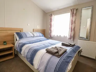 a bedroom with a bed with two towels on it at Rosella 38 in Morecambe