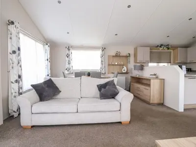 a living room with a couch and a kitchen at Rosella 38 in Morecambe