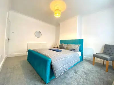 a bedroom with a blue bed and a chair at Merseyside in Birkenhead