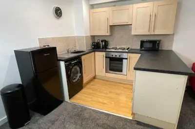 a kitchen with a black refrigerator and a stove at Moda Wigan 2 - Stylish 2 Bed in Central Wigan in Wigan
