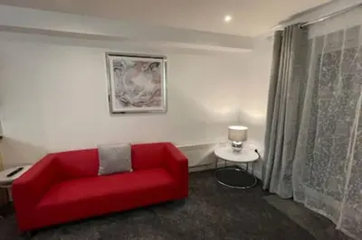 a living room with a red couch and a table at Moda Wigan 2 - Stylish 2 Bed in Central Wigan in Wigan