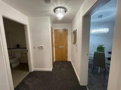 a hallway with a door and a room with a toilet at Moda Wigan 2 - Stylish 2 Bed in Central Wigan in Wigan