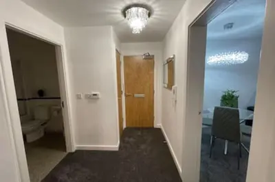 a hallway with a door and a room with a table at Moda Wigan 2 - Stylish 2 Bed in Central Wigan in Wigan