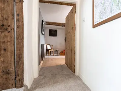 a hallway with a door leading to a living room at Longlands Farm Cottage in Grange Over Sands