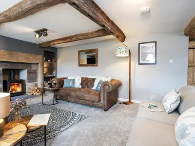 a living room with a couch and a fireplace at Longlands Farm Cottage in Grange Over Sands