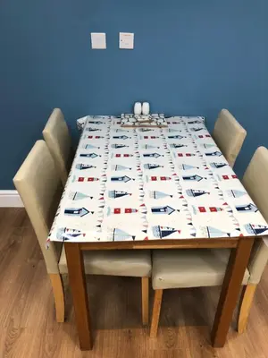 a dining room table with a tablecloth on it at A secluded Garden Room in sunny Southport in Southport