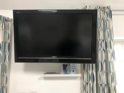 a flat screen tv sitting on a shelf at A secluded Garden Room in sunny Southport in Southport