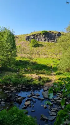 a river with rocks and a hill in the background at Cadshaw Country Views in Darwen