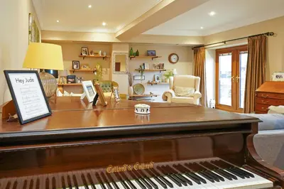 a living room with a piano and a living room with a couch at Cadshaw Country Views in Darwen