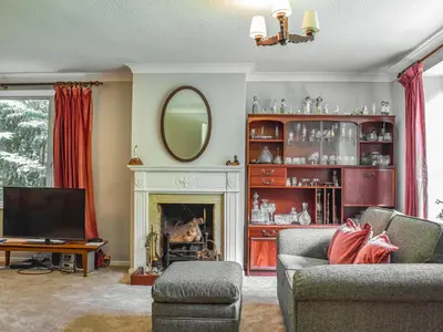 a living room with a fireplace and a mirror at Court House in Halsall