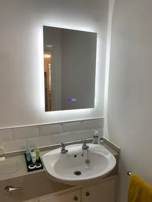 a bathroom with a white sink and a mirror at Kensington Luxury Apartment on Gated Development in Leafy edge of Chorley Town Centre in Chorley