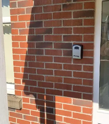 a shadow of a mailbox on a brick wall at Kensington Luxury Apartment on Gated Development in Leafy edge of Chorley Town Centre in Chorley