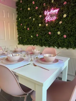 a white table with pink chairs and a sign that reads optimum place at #1 Most Viral Pink House w Ball Pit in Liverpool