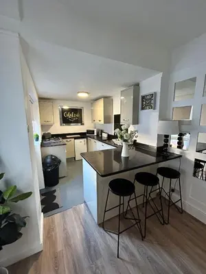 a kitchen with a counter and two stools in it at Westview House by Sasco Apartments in Blackpool