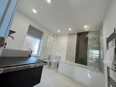 a bathroom with a tub and a sink and a toilet at Westview House by Sasco Apartments in Blackpool