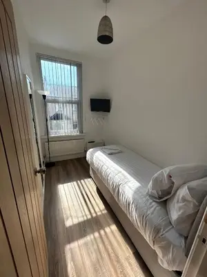 a small bedroom with a bed and a window at Westview House by Sasco Apartments in Blackpool