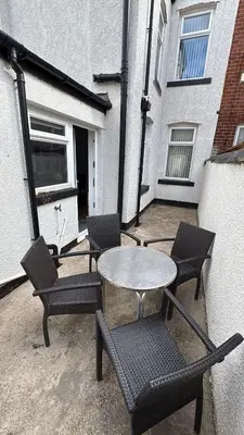 a patio with a table and chairs in front of a building at Westview House by Sasco Apartments in Blackpool