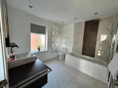 a bathroom with a sink and a tub and a toilet at Westview House by Sasco Apartments in Blackpool