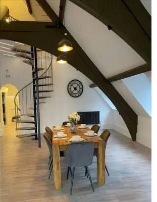 a dining room with a wooden table and chairs at Central Luxurious Stylish Church Conversion in Blackpool