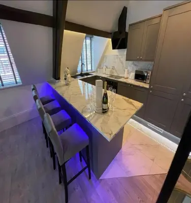 a kitchen with a large table with purple chairs at Central Luxurious Stylish Church Conversion in Blackpool