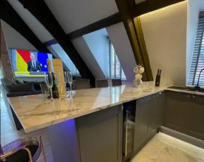 a kitchen with a counter with a sink and a tv at Central Luxurious Stylish Church Conversion in Blackpool