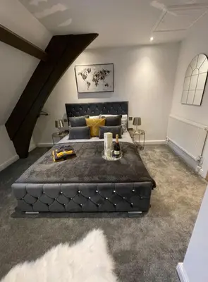 a bedroom with a large black bed in a room at Central Luxurious Stylish Church Conversion in Blackpool