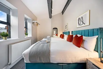 a bedroom with a large bed with red pillows at Host & Stay - The Coachouse at Pilgrim St in Liverpool