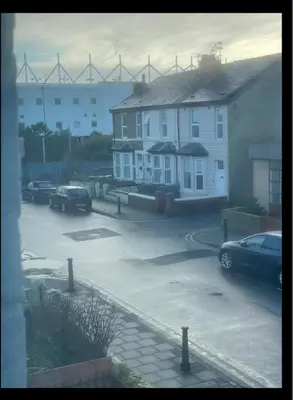 a parking lot with cars parked in front of houses at Newly Refurbished Clarendon Apartments, Free WIFI, Parking in Blackpool
