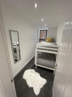 a bedroom with a bunk bed with a mirror and a rug at Newly Refurbished Clarendon Apartments, Free WIFI, Parking in Blackpool