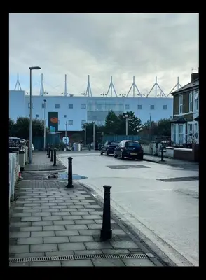 a parking lot with cars parked in front of a building at Newly Refurbished Clarendon Apartments, Free WIFI, Parking in Blackpool