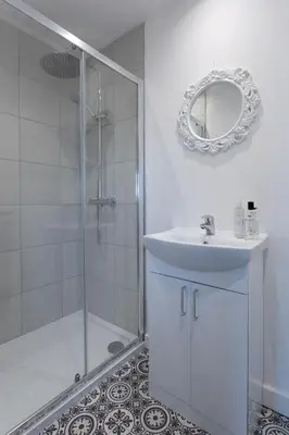 a bathroom with a shower and a sink and a mirror at RESIDENCY LUXURY SEAFRONT HOTEL in Blackpool