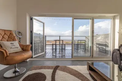 a living room with a couch and a large window at RESIDENCY LUXURY SEAFRONT HOTEL in Blackpool