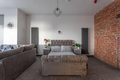 a living room with a couch and a brick wall at RESIDENCY LUXURY SEAFRONT HOTEL in Blackpool