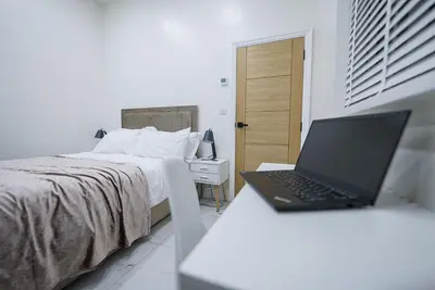 a laptop sitting on a desk next to a bed at Cozy Charming Bungalow BRAND NEW in Preston