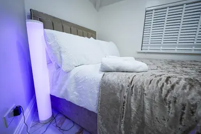 a bedroom with a bed with a white bedspread at Cozy Charming Bungalow BRAND NEW in Preston