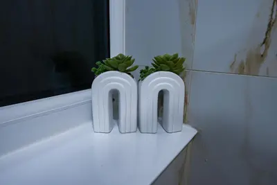 two white pots with plants on a window sill at Cozy Charming Bungalow BRAND NEW in Preston