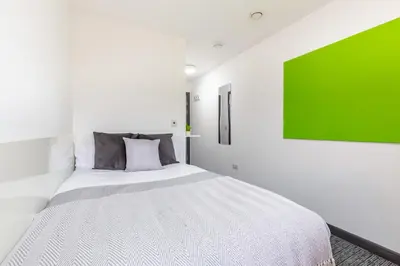 a bedroom with a large bed with a green painting on the wall at For Students Only Glassworks in Liverpool in Liverpool
