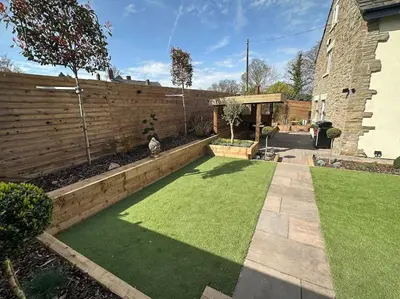 a garden with green grass and a fence at 1 The Cottage in Upholland