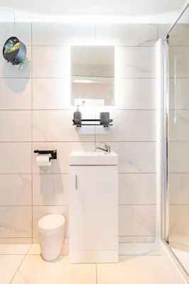 a white bathroom with a toilet and a sink at 1 The Cottage in Upholland