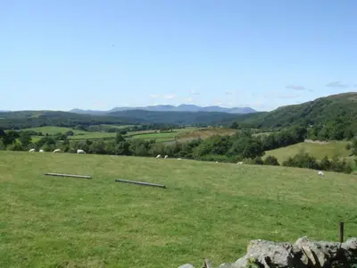 a field of green grass with sheep in the distance at Farriers Fold in Grange Over Sands