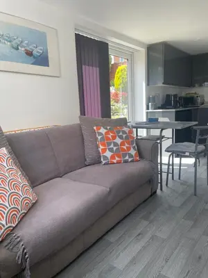 a living room with a couch and a table and a kitchen at The Hideaway-Sharples-Bolton in Bolton